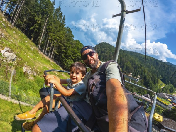 A man and a child are sitting on a ski lift