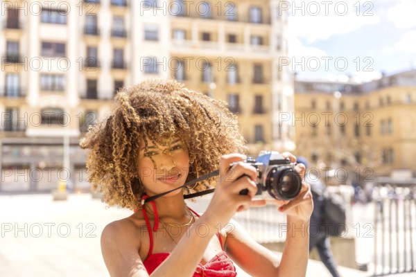 Horizontal photo with copy space of a beauty brunette female tourist taking photos with a camera while visiting a city
