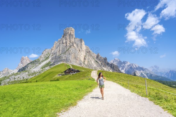 Female tourist enjoying hiking on a sunny summer day at the scenic giau pass in the italian dolomites
