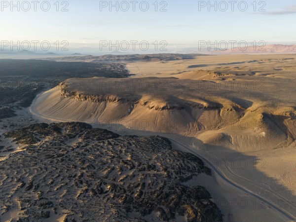 Aerial view of a vast desert landscape with bare rocks and a distant horizon, Argentina, volcanoes, lava field, Antofagasta, South America
