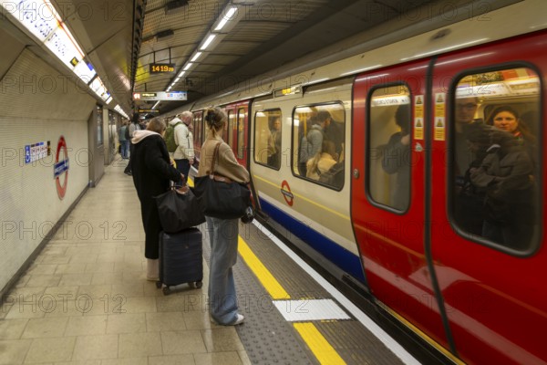 Crowded underground tube train arriving at station platform, Kings Cross Station, London, England, Uk