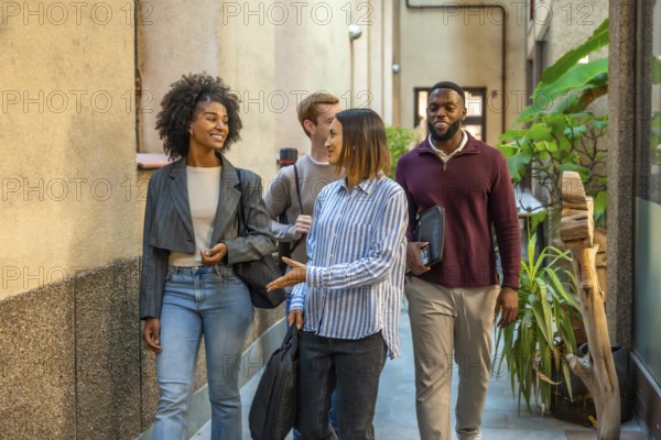 Group of diverse males and females colleagues walking out the coworking talking and smiling
