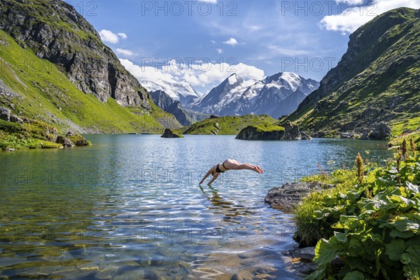 Woman taking a dip, cooling off in the mountain lake Lac de Louvie, behind the summit of the Grand Combin, Val de Bagnes, Valais, Switzerland, Europe