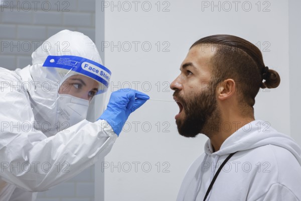 Cologne, North Rhine-Westphalia, Germany - Covid rapid test at the Medicare test centre, throat swab on cotton swab (posed scene)