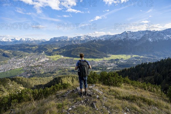 View of Garmisch-Partenkirchen and mountain panorama, mountaineer on hiking trail to Kramerspitz, in autumn, Ammergau Alps, in autumn, Bavarian Prealps, Bavaria, Germany, Europe