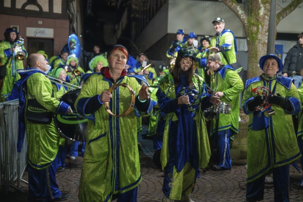 Music group in green and blue costumes with instruments at a night-time performance, carnival, Calw, Black Forest, Calw district, Germany, Europe