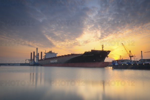 View of a harbour basin and a freighter at sunset, Bremerhaven, Bremen, Germany, Europe