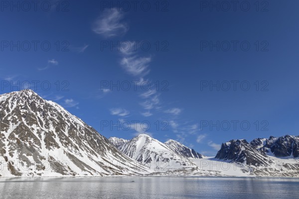 Cirrus uncinus clouds above mountain with glacier along Magdalenefjorden, fjord in Albert I Land on Svalbard, Spitsbergen, Norway, Europe