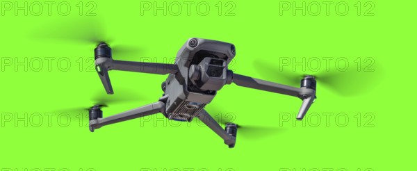 Isolated unmanned aircraft system (UAV) quadcopter drone in the air over A green screen