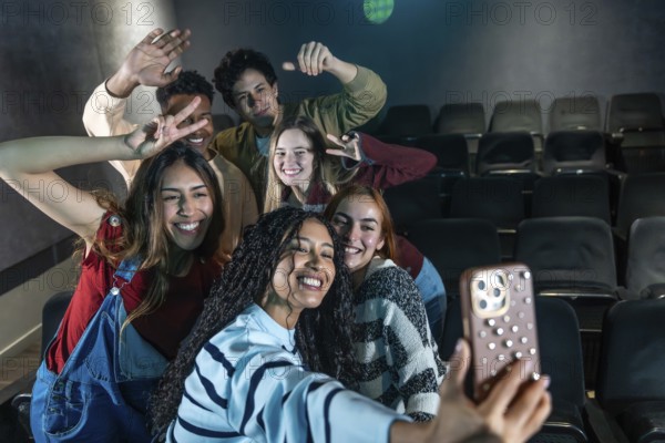 Group of smiling friends taking a selfie at the cinema, enjoying a movie night out together