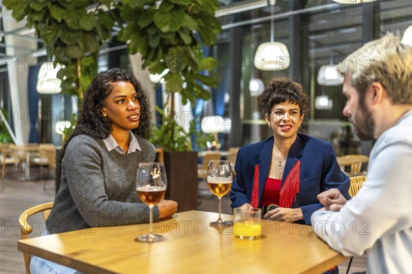 Multiracial friends taking drinking beer in a night bar terrace enjoying together