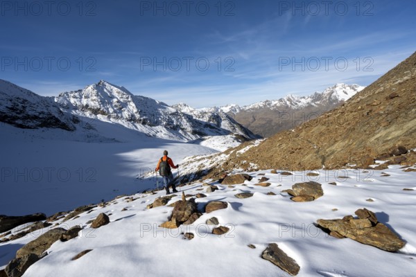 Mountaineer on a hiking trail with snow, descent from Ramoljoch at Spiegelferner, autumnal mountain landscape, mountain panorama, Ötztal Alps, Tyrol, Austria, Europe