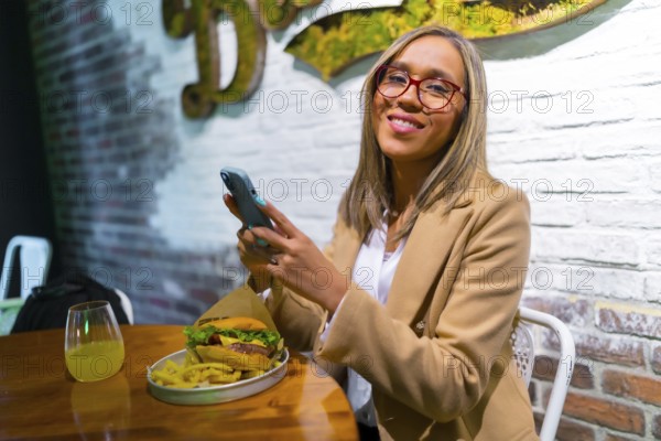 Latin blonde woman using phone while eating in a fast food restaurant