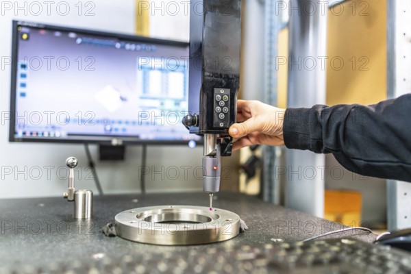 Man working with three-dimensional verification and measuring machine in a cnc innovative factory