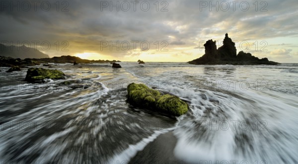 Dramatic cloudy atmosphere with rock formation at rising tide at sunset on the beach of Playa de Benijo, Tenerife, Canary Island, Spain, Europe