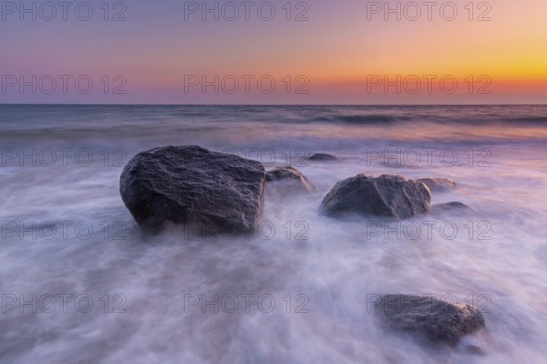 Large boulders in surf at Brodtener Ufer, Brodten Steilufer, cliff in the Bay of Lübeck along the Baltic Sea at sunrise, Schleswig-Holstein, Germany, Europe