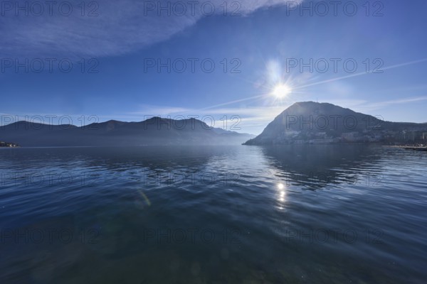 Lake, hills, haze, fog, backlight, blue sky with veil clouds, Lake Lugano, Lugano, Lugano district, Ticino, Switzerland, Europe