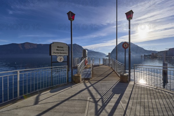 Ferry terminal Lugano-Centrale, public transport, jetty, lanterns, metal railings, backlight of the sun, Lake Lugano, Lugano, district Lugano, canton Ticino, Switzerland, Europe