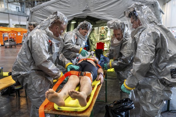 Decontamination of injured persons after an assumed accident involving hazardous substances, fire brigade and aid organisations practise setting up and operating a decontamination station, injured persons are sighted and then washed in a special shower tent to remove possible hazardous substances and chemicals in order to avoid further injuries, the emergency services wear special, ventilated protective suits, large-scale exercise by the Essen fire brigade