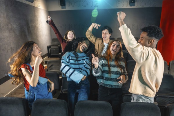 Cheerful multi ethnic friends dancing and enjoying music during movie disco event in cinema theater