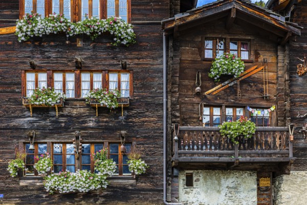 Wooden houses decorated with flowers in the historic village centre, Grimentz, Val d'Anniviers, Valais Alps, Canton Valais, Switzerland, Europe