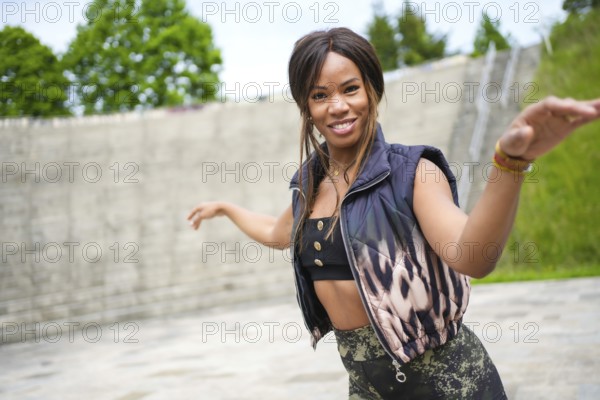 Happy beauty latin woman dancing alone in a park