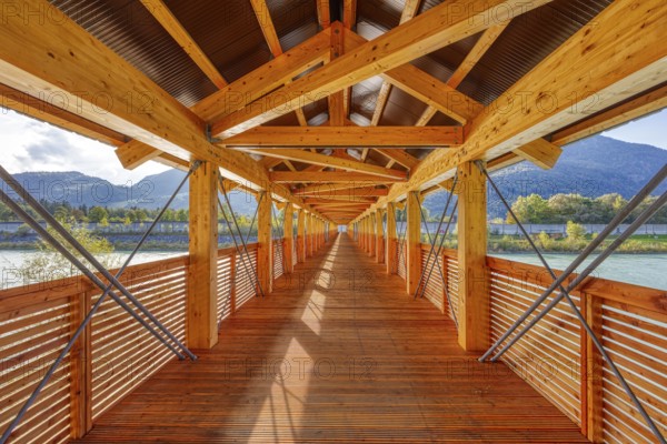 Perspective of a wooden bridge, framed by mountains and river, with modern construction, Inn footbridge, bridge over the Inn