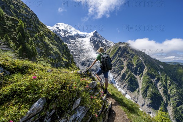 Hiker on hiking trail La Jonction, mountain landscape, view of glacier Glacier de Taconnaz, Chamonix, Haute-Savoie, France, Europe