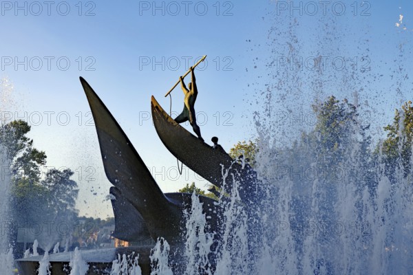 A dynamic statue surrounded by spraying water fountains at sunrise, memorial to the whalers of centuries past, Sandefjord, Norway, Europe