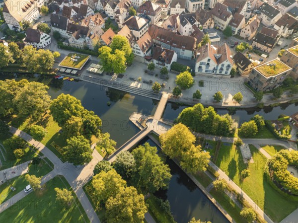 Aerial view of houses with red roofs, a river with a bridge and many trees in a park, Nagold, Black Forest, Germany, Europe