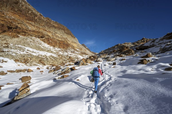 Mountaineer on a hiking trail with snow on the Ramoljoch, autumnal mountain landscape, Ötztal Alps, Tyrol, Austria, Europe
