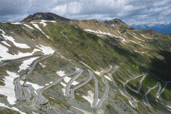 Stilfserjoch, Vinchgau, South Tyrol, Italy, Stilfser Joch pass road, the ascent over the tight bends, the narrow hairpin bends is a popular destination for cyclists, motorcyclists and motorists, snow-covered mountain landscape of the Swiss Alps in the background, Europe