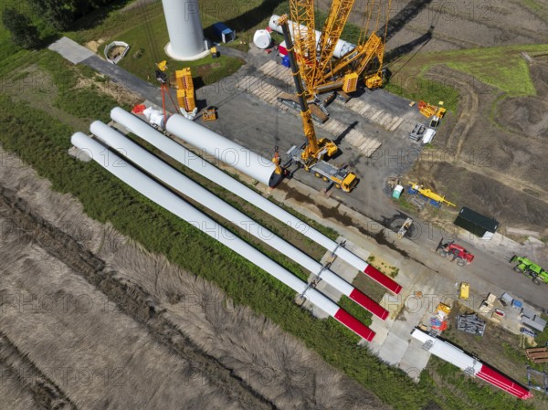 Dorsten, North Rhine-Westphalia, Germany, construction of a wind turbine, the first wind turbine of the Grosse Heide wind farm. The rotor blades are ready for assembly. A large mobile crane places the tower elements, the rings, on top of each other. This wind turbine will have a rated output of 5, 500 kW, Europe