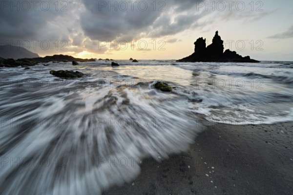 Dramatic cloudy atmosphere with rock formation at rising tide at sunset on the beach of Playa de Benijo, Tenerife, Canary Island, Spain, Europe