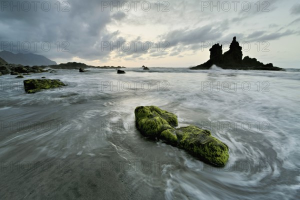 Dramatic cloudy atmosphere with rock formation at rising tide at sunset on the beach of Playa de Benijo, Tenerife, Canary Island, Spain, Europe