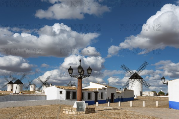 Windmills and street lamp in a charming village under a blue sky with clouds, windmills and village, Campo de Criptana, Ciudad Real province, Castilla-La Mancha, Route of Don Quixote, Spain, Europe