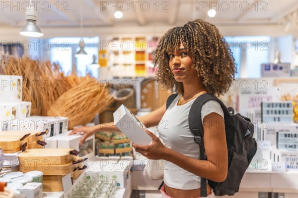 Latin young and beauty woman with curly hair shopping souvenirs in a store with variety of products in the city