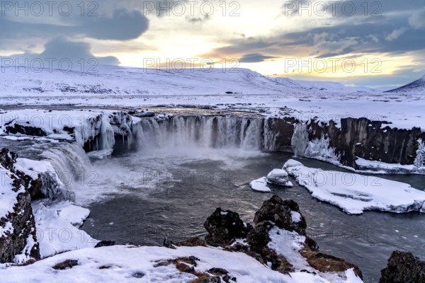 Beautiful landscape at frozen Godafoss waterfall at sunset in winter, Iceland, Europe