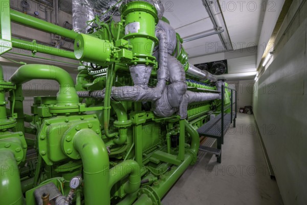 Biogas plant, gas-powered engine for electricity production, generator, in combined heat and power plant, the gas is produced from various biomass, including waste from the food industry, the electricity is produced in combined heat and power plants with the biogas produced and fed into the grid, the heat is sent to 70 households via a local heating network, part of the gas is processed and fed into the Thyssengas gas network, Anröchte, North Rhine-Westphalia, Germany, Europe