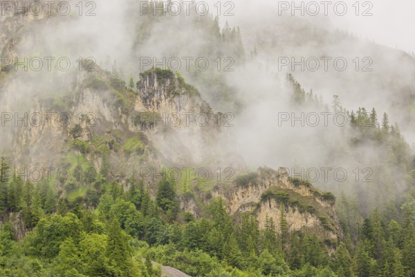 Wisps of mist cover the Karwendel mountains in the Großer Ahornboden nature reserve, Eng Valley, Tyrol, Austria, Europe