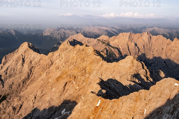Impressive rocky mountain landscape, steep mountain ridge, Jubiläumsgrat with Alpspitze, mountain panorama from the summit of the Zugspitze, alpenglow at sunset, Northern Limestone Alps, Wetterstein Mountains, Bavaria, Germany, Europe