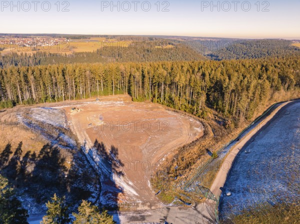 View of deforested land and neighbouring forests under a clear sky, landfill. Neubulach, Black Forest, Germany, Europe
