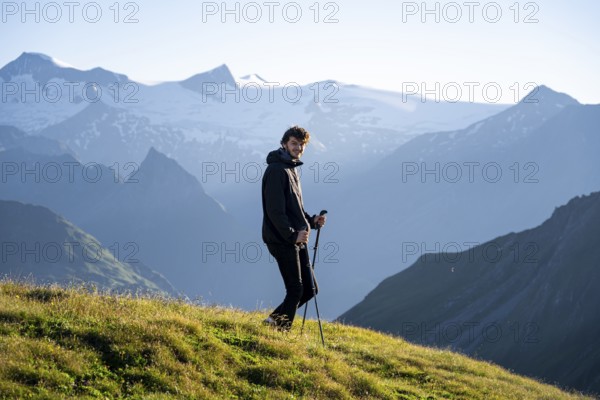 Hiker enjoying the mountain panorama in the morning, Venediger group, behind Dreiherrenkopf, Simonysitze and Großer Geiger, Hohen Tauern, Austria, Europe