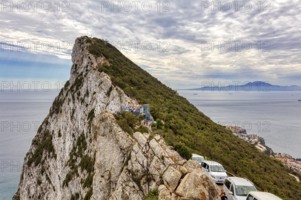 Steep rocky outcrop with cars along the coast and views of the sea, Gibraltar, Europe