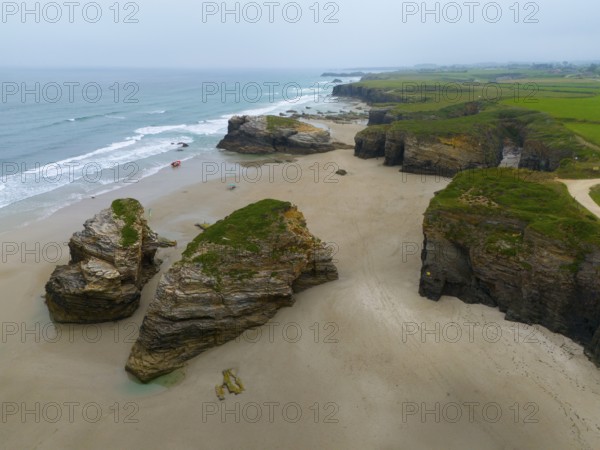 Wide beach with scattered large rock formations and calm water, bordered by steep coastal cliffs, aerial view, Praia das Catedrais, Playa de las Catedrales, Cathedral beach, As Catedrais beach, Cantabrian Sea, Ribadeo, Galicia, Galicia, Spain, Europe