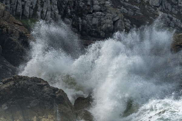 Large waves of the Atlantic Ocean crash against the rocks of a cliff. Camaret sur mer, Crozon, Finistere, Brittany, France, Europe