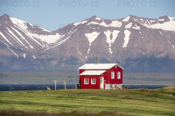 Red house near Dalvik or Dalvik, mountains with snow remains, Eyjafjörður or Eyjarfjörður or Eyjafjördur, Iceland, Europe
