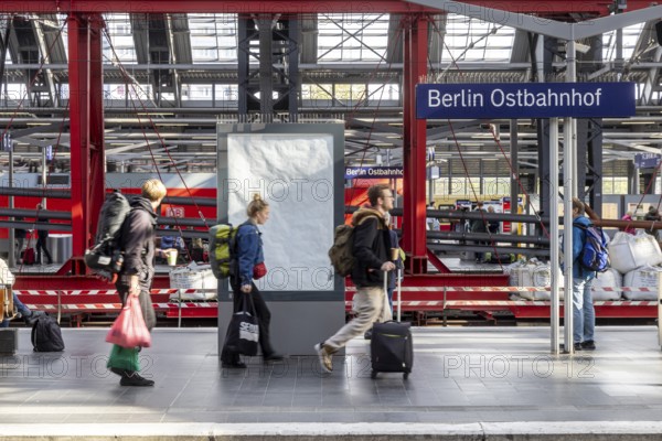 Construction site at Ostbahnhof station with station sign, travellers on the platform. Berlin, Germany, Europe