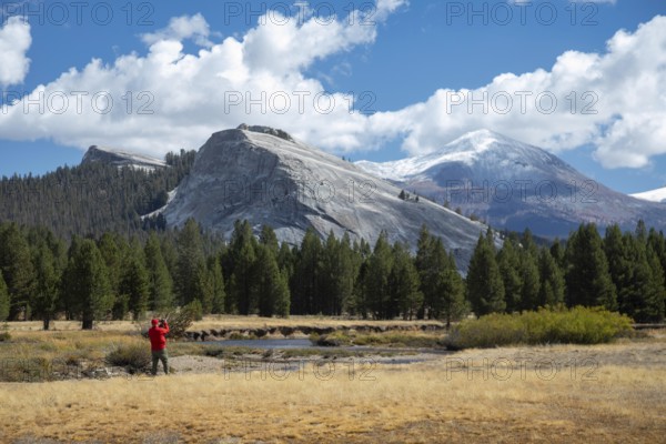 Yosemite National Park, California - A man takes pictures of Lembert Dome above Tuolumne Meadows in Yosemite National Park