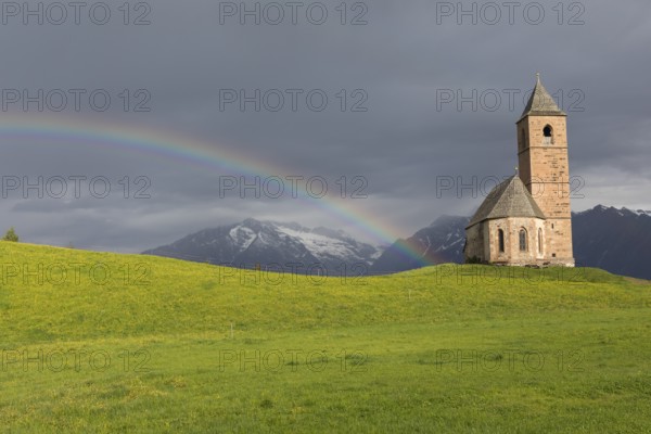 Church St. Kathrein, 39010 Hafling, Italy with a rainbow in the background. The church is from the 13 th century
